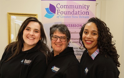 Volunteers in front of a Community Foundation sign