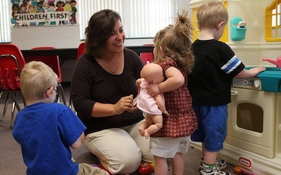 A volunteer playing with little kids