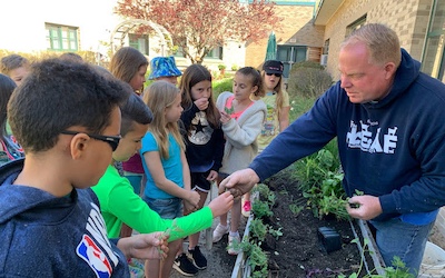 A volunteer teaching kids how to garden
